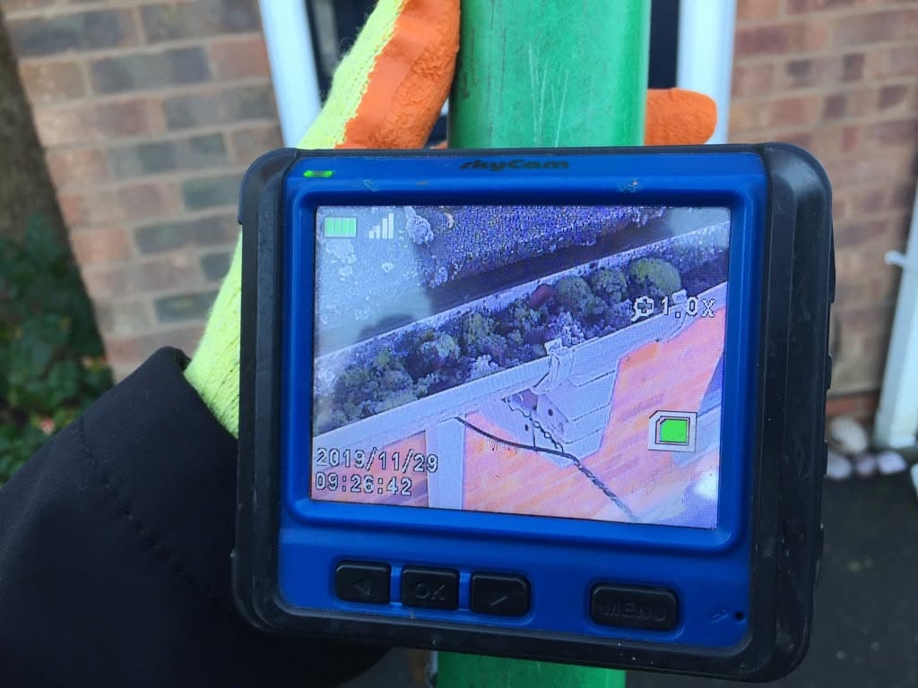 SkyCam inspection screen showing a moss-filled gutter